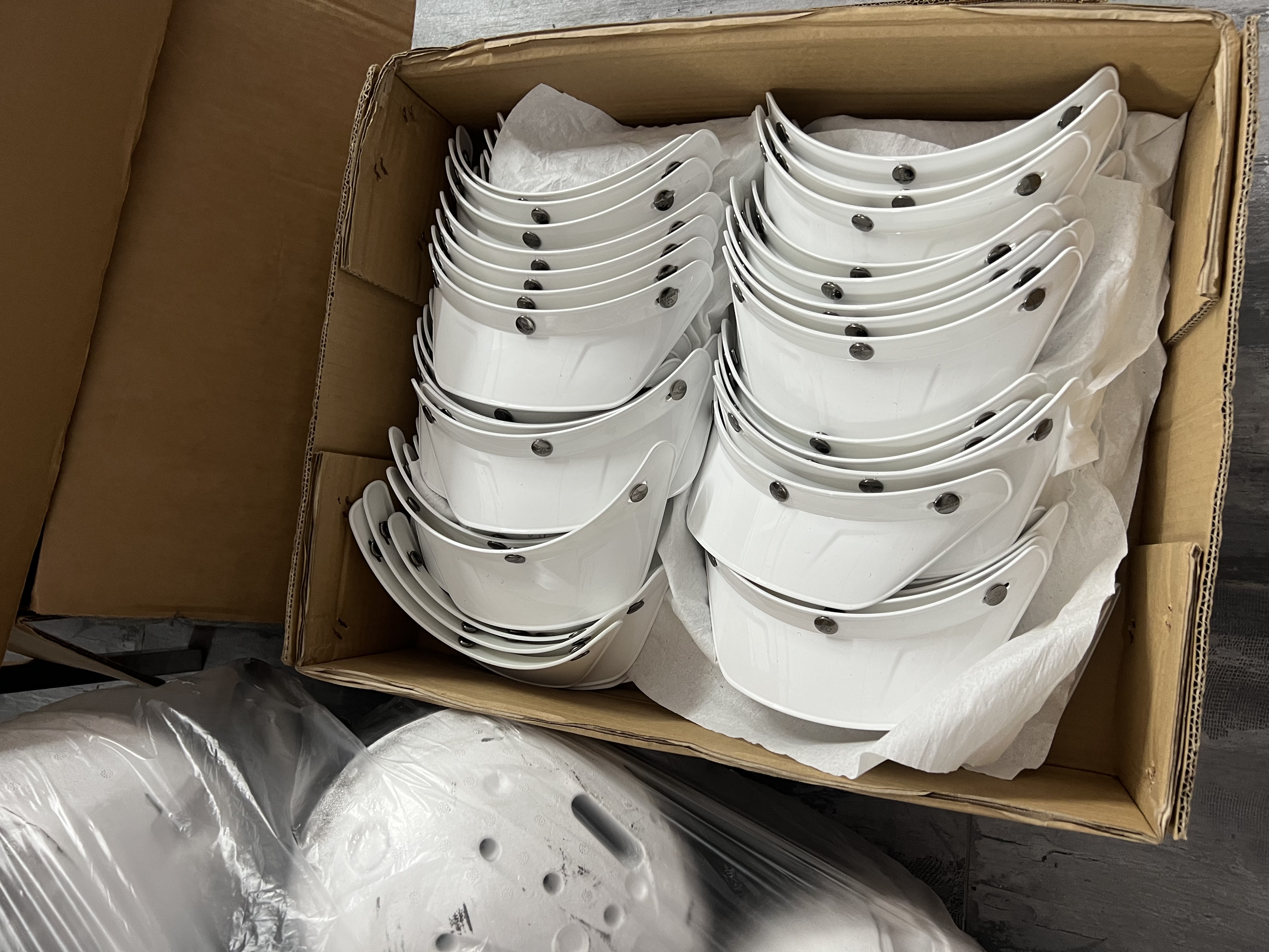White helmet components arranged inside a carton during a Taotao factory visit