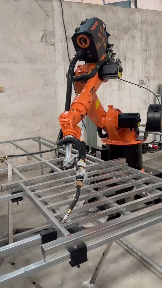 Robot application video frame showing metal-frame welding